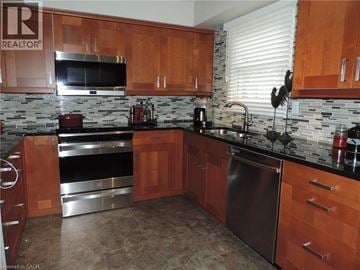 Burlington townhouse for rent - A kitchen with wooden cabinets and a black counter top.