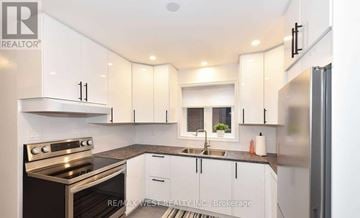 Toronto (Beechborough-Greenbrook) triplex for rent - A modern kitchen with white cabinets and stainless steel appliances.