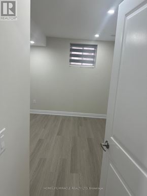 Brampton (Credit Valley) apartment for rent - A hallway with a wooden floor and white walls.
