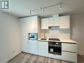 Toronto (Kensington-Chinatown) condo for rent - A kitchen with white cabinets and appliances is on the market.