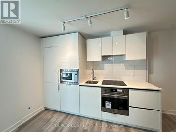 Toronto (Kensington-Chinatown) condo for rent - A kitchen with white cabinets and appliances is on the market.