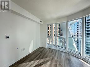 Toronto (Kensington-Chinatown) condo for rent - A room with a view of the city through large windows.