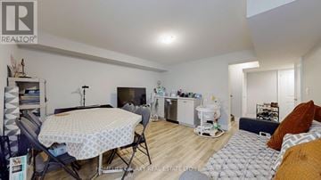 Pickering apartment for rent - A living room with a dining table and chairs, a sofa, and a baby walker.