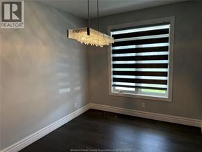 Windsor apartment for rent - A room with a chandelier, a window with blinds, and a wall with a logo.