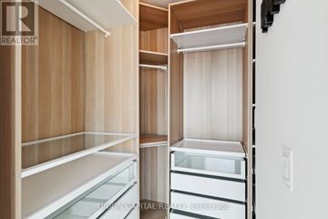 Toronto (Waterfront Communities) condo for rent - A kitchen with wooden cabinets and white appliances.