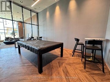Pickering (Bay Ridges) condo for rent - A modern living room with a long black sofa and wooden flooring.