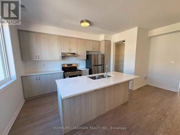 Oakville (Jm Joshua Meadows) townhouse for rent - A kitchen with wooden cabinets and a white island.
