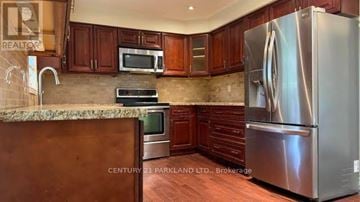 Toronto (St. Andrew-Windfields) apartment for rent - A kitchen with wooden cabinets and a stainless steel refrigerator.