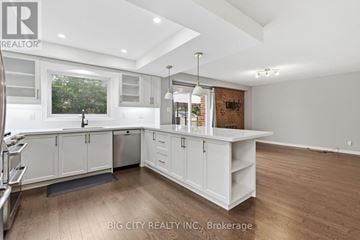 Toronto (Steeles) apartment for rent - A spacious kitchen with white cabinets and a large island.