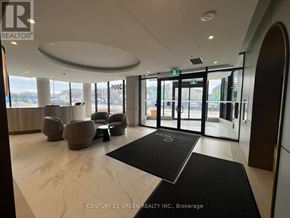 Oakville (Jm Joshua Meadows) condo for rent - A reception area with a black and white rug and a glass door.