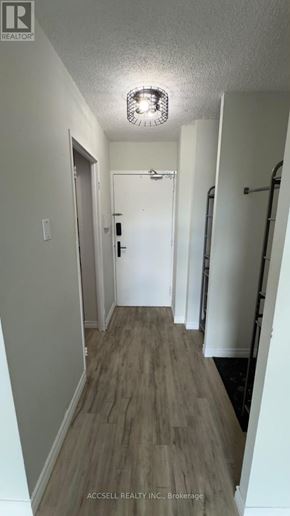 Toronto (Black Creek) condo for rent - A long hallway with wood floors and white walls.