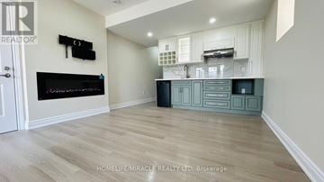 Brampton (Credit Valley) apartment for rent - A modern kitchen with a black fridge and a wooden floor.