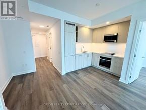 Vaughan (Vaughan Corporate Centre) condo for rent - A kitchen with white cabinets and a microwave above the stove.