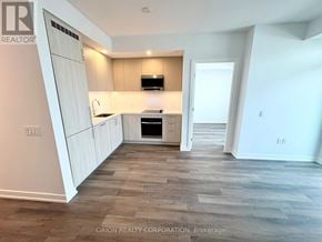 Vaughan (Vaughan Corporate Centre) condo for rent - A kitchen with white cabinets and a wooden floor.