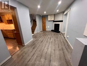 Brampton (Brampton South) apartment for rent - A spacious room with wooden flooring and a staircase on the left side.