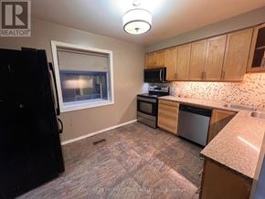 Brampton (Brampton South) apartment for rent - A kitchen with a black fridge, microwave, oven and dishwasher.