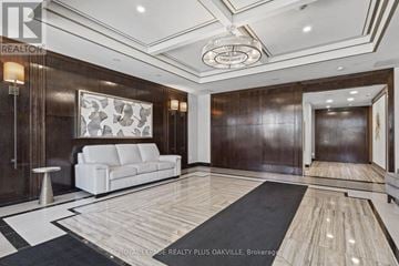 Oakville (Ro River Oaks) condo for rent - A spacious living room with a white sofa and a wooden floor.