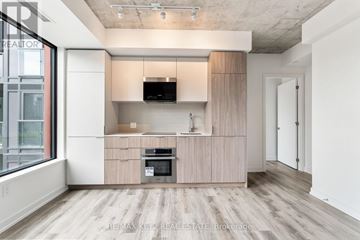 Toronto (Moss Park) condo for rent - A modern kitchen with wooden cabinets and a built-in oven.
