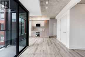 Toronto (Moss Park) condo for rent - A modern kitchen with a wooden floor and white walls.