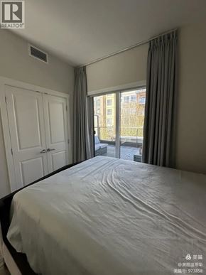 Vancouver apartment for rent - A bedroom with a large bed and a window overlooking a city.