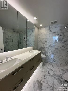 Vancouver apartment for rent - A bathroom with marble floors and a large mirror.