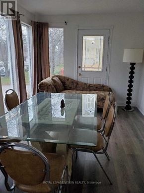 Fort Erie (Central) duplex for rent - A glass table with chairs in front of a window with a view of a street.