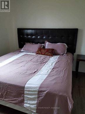 Fort Erie (Central) duplex for rent - A bed with a pink comforter and pillows in a room.
