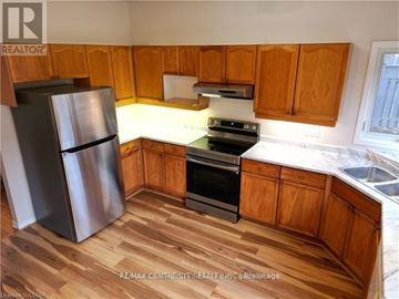 London North (North B) house for rent - A kitchen with wooden cabinets and a stainless steel refrigerator.