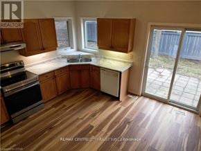 London North (North B) house for rent - A kitchen with wooden cabinets and a stove top oven.