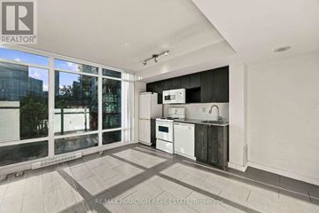 Toronto (Waterfront Communities) condo for rent - A kitchen with a white fridge, microwave, and oven in a modern apartment.
