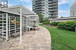 Toronto (Mimico) condo for rent - A patio area with a white pergola and a stone walkway.