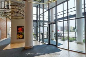 Toronto (Mimico) condo for rent - A modern office lobby with a large glass wall and a wooden floor.