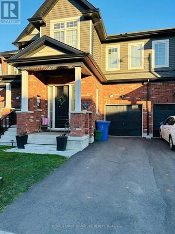 Erin townhouse for rent - A house with a white car parked in front of it.