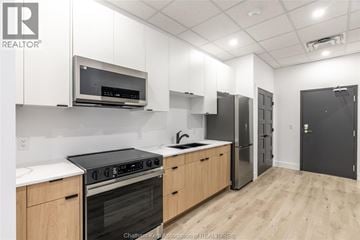 Chatham apartment for rent - A kitchen with white cabinets and a black stove top oven.