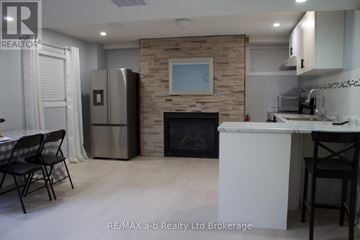 Woodstock (Woodstock - South) apartment for rent - A kitchen with a stone fireplace and a refrigerator.