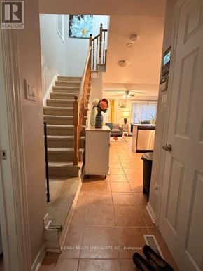 Brampton (Fletcher's Meadow) apartment for rent - A woman is standing in a kitchen with a staircase in the background.