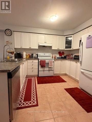 Brampton (Fletcher's Meadow) apartment for rent - A kitchen with white cabinets and a white fridge.