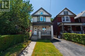 Hamilton (Gibson) apartment for rent - A house with a white door and a small porch is surrounded by greenery.