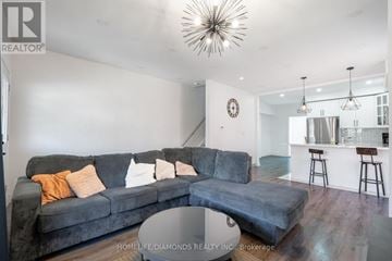 Hamilton (Gibson) apartment for rent - A living room with a grey couch and a bar area in the background.