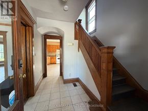 Niagara Falls (Downtown) apartment for rent - A hallway with a staircase and a door on the left.