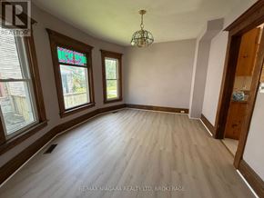 Niagara Falls (Downtown) apartment for rent - A room with wooden floors and a chandelier hanging from the ceiling.