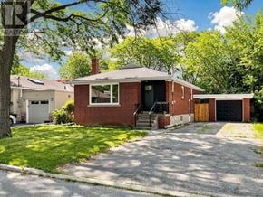 Toronto (Clanton Park) apartment for rent - A red brick house with a black door and a garage.