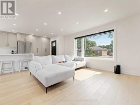 Toronto (Clanton Park) apartment for rent - A spacious living room with a large window overlooking a backyard.