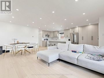 Toronto (Clanton Park) apartment for rent - A modern living room with a white couch and a dining table.