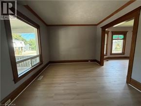 Niagara Falls apartment for rent - A room with wooden floors and a window overlooking a street.