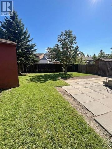 Grande Prairie apartment for rent - A backyard with a green lawn and a concrete patio.