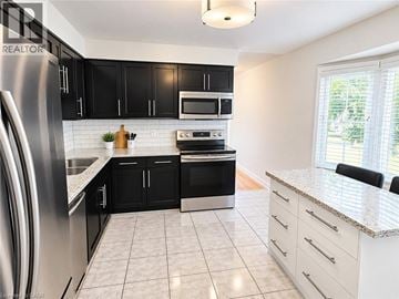 Hamilton townhouse for rent - A modern kitchen with black cabinets and stainless steel appliances.