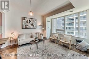 Toronto (Niagara) condo for rent - A living room with a white couch, a coffee table, and a large window with a view of a building.