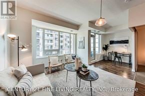 Toronto (Niagara) condo for rent - A well-lit living room with a large window and a view of a building outside.