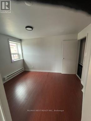 Toronto (Trinity-Bellwoods) apartment for rent - A room with a wooden floor and white walls.